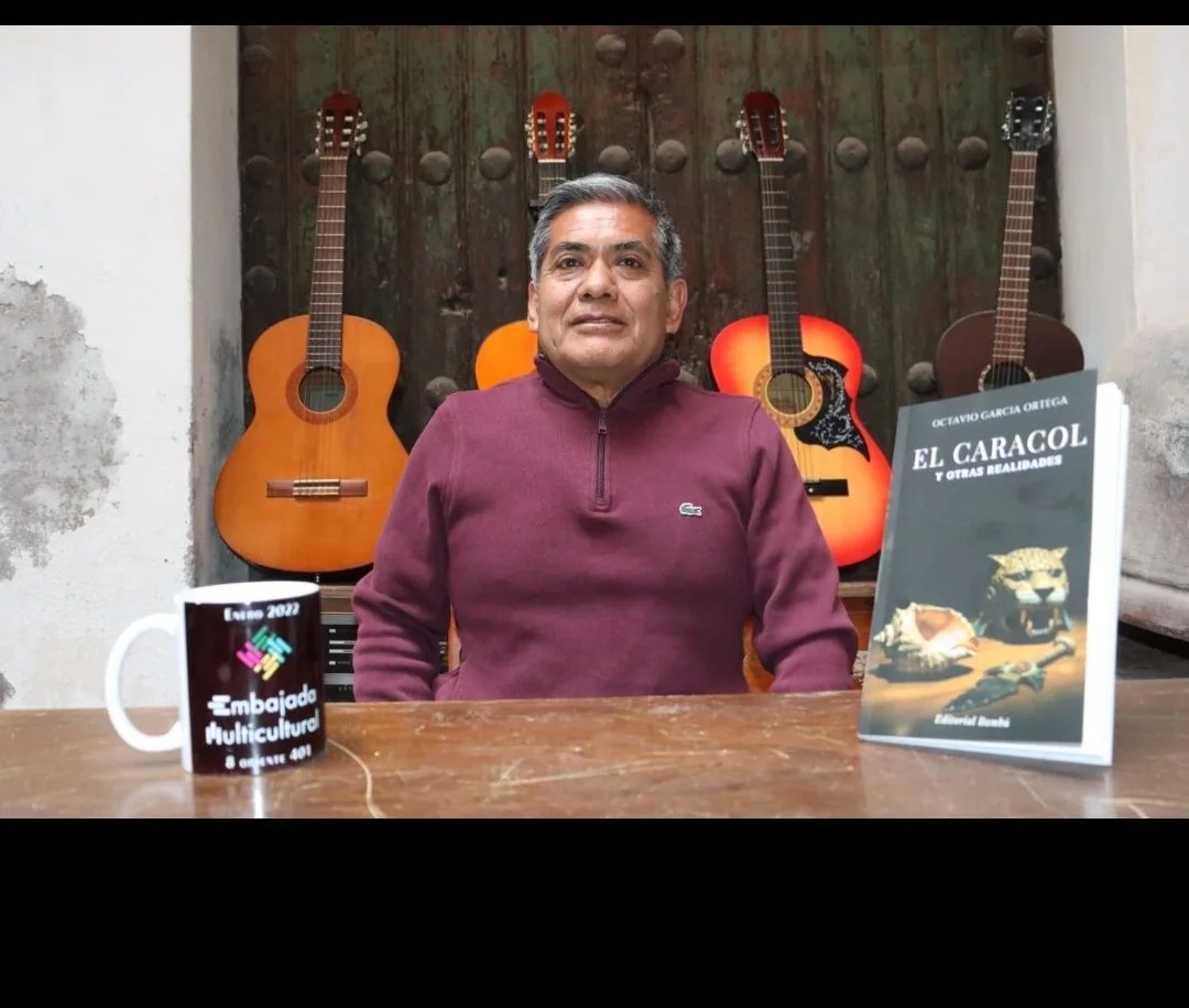 Octavio García Ortega en su estudio con guitarras y su libro